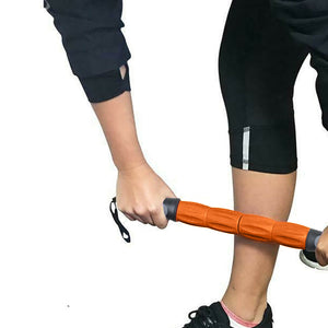 Orange massage stick with 4 rollers and a wrist strap on the end